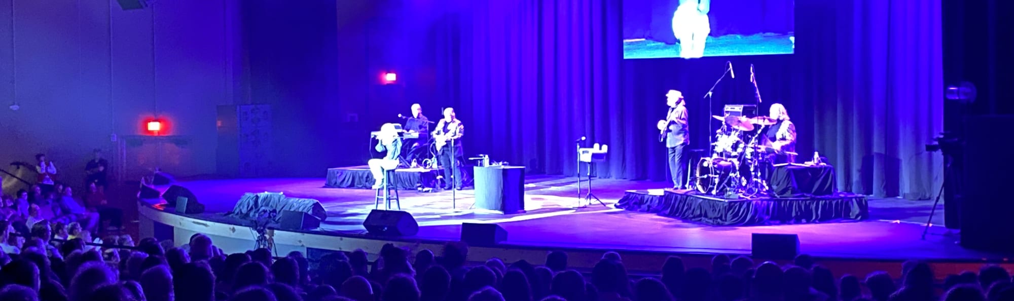 signer on stage in chair washed out by the lights East Lansing